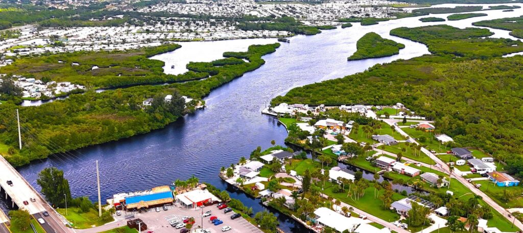 Aerial view of a waterfront community along a winding river and surrounding wetlands