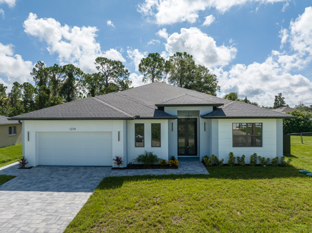 Elevated aerial view of the front exterior, driveway, and entry of a single-story home