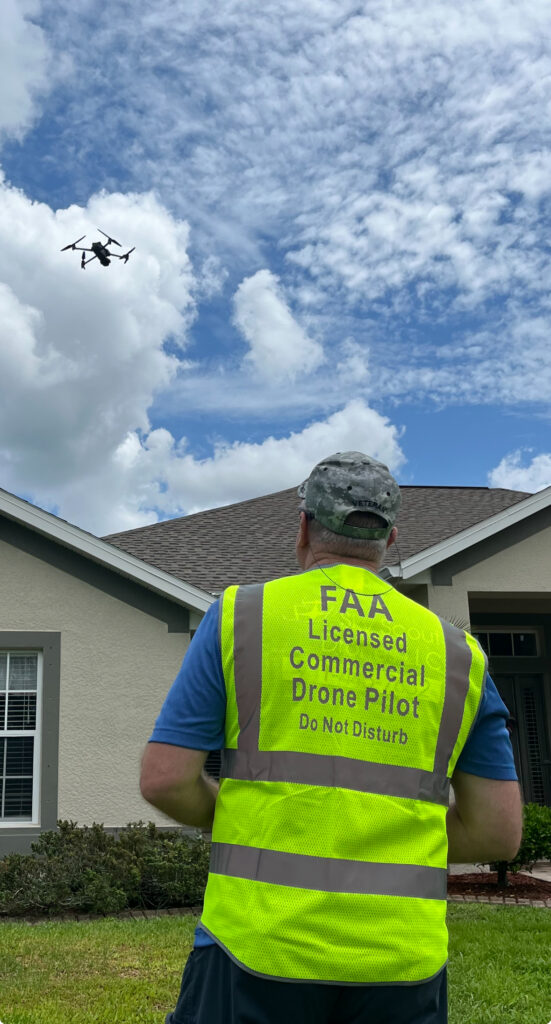 Chief Pilot Dan Bidwell operating a drone while wearing an FAA Licensed Commercial Drone Pilot safety vest
